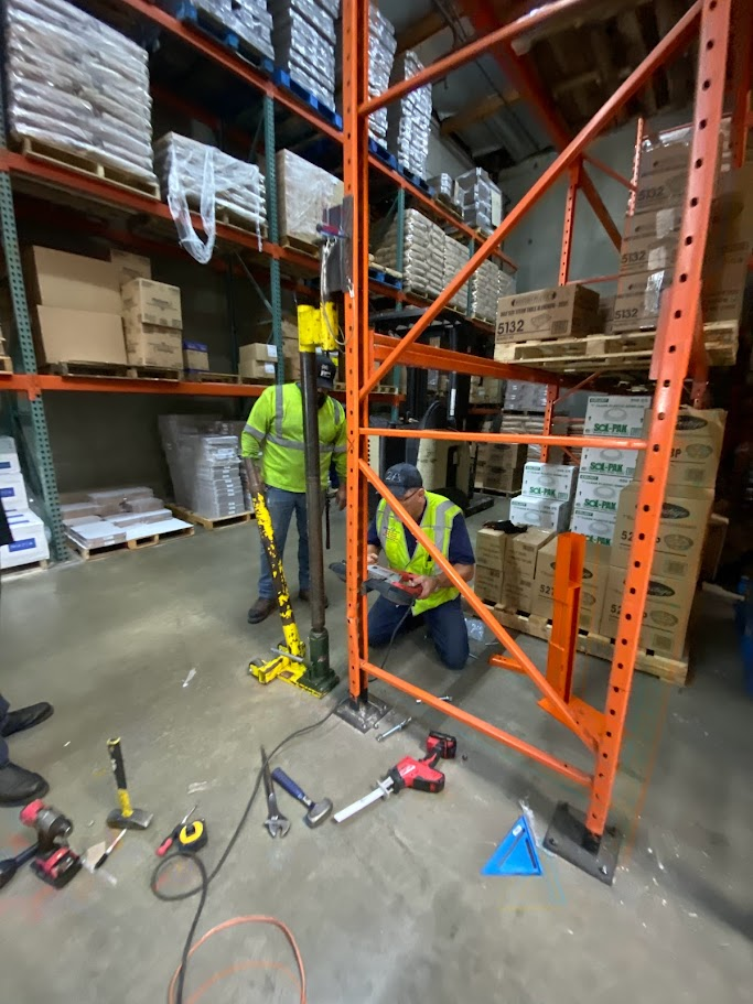 two people repairing pallet rack in a warehouse in Inland Empire